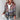 Femme portant une veste à capuche à rayures multicolores, avec poignets bordeaux et jeans déchirés, tenant un gobelet blanc.

