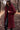 Manteau teddy bordeaux chaud porté avec un pantalon noir