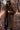 Manteau teddy marron foncé porté par une femme avec lunettes noires