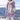 Veste lavande et blanche à capuche avec poche kangourou portée face à la montagne