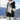 Veste noire à capuche et rayures blanches, portée en extérieur